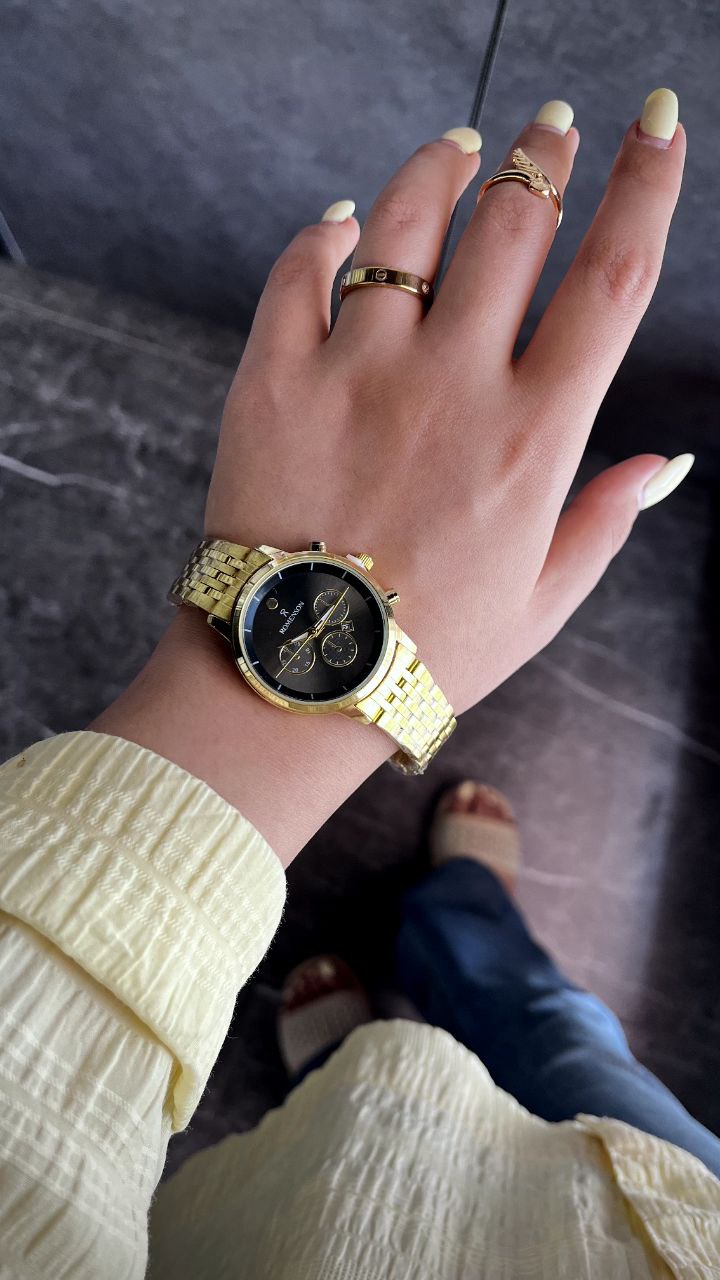 ساعت زنونه  رومانسون دارای روز شمار قفل کلیپسی  بند استیل موتورکوارتز طرح کرنوگراف  رنگ طلایی